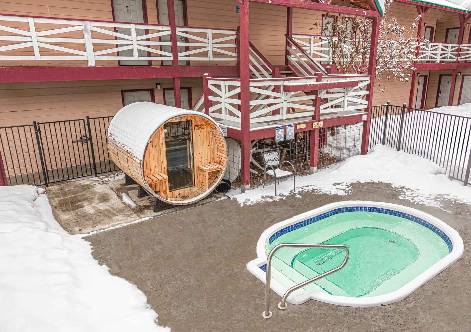 Hot tub and barrel sauna in the snowy courtyard