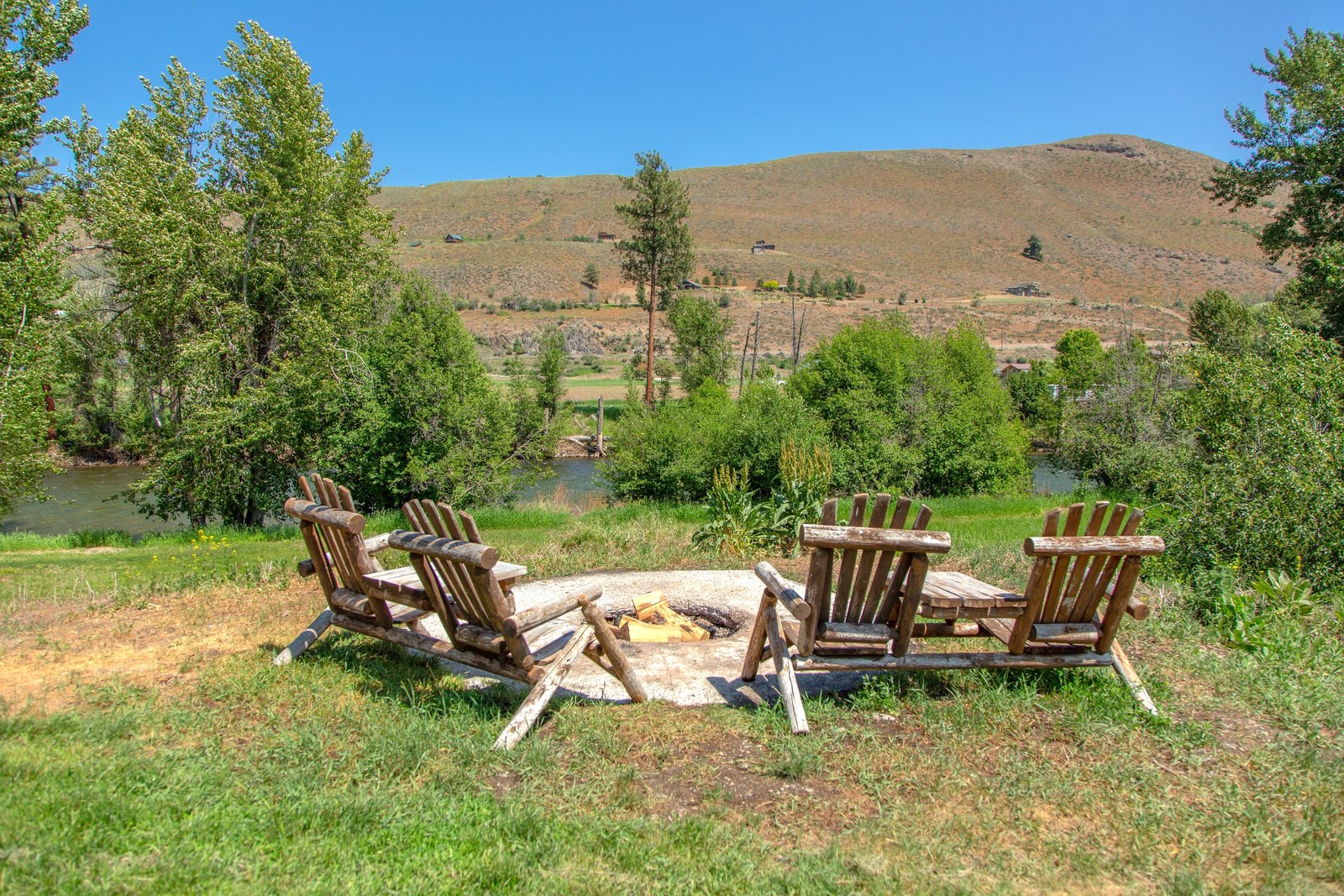 Adirondack chairs on the lawn beside the Methow River at Abbycreek Inn